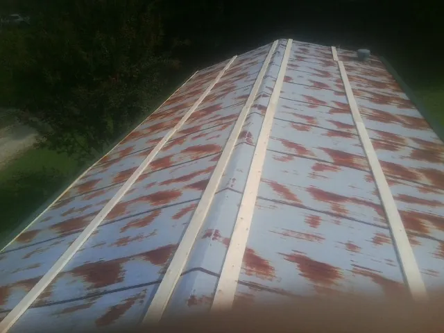 Rusted metal roof panels with new wood purlins before replacement — Storm Damage Roof Repair in Beckley by Roofing Brothers