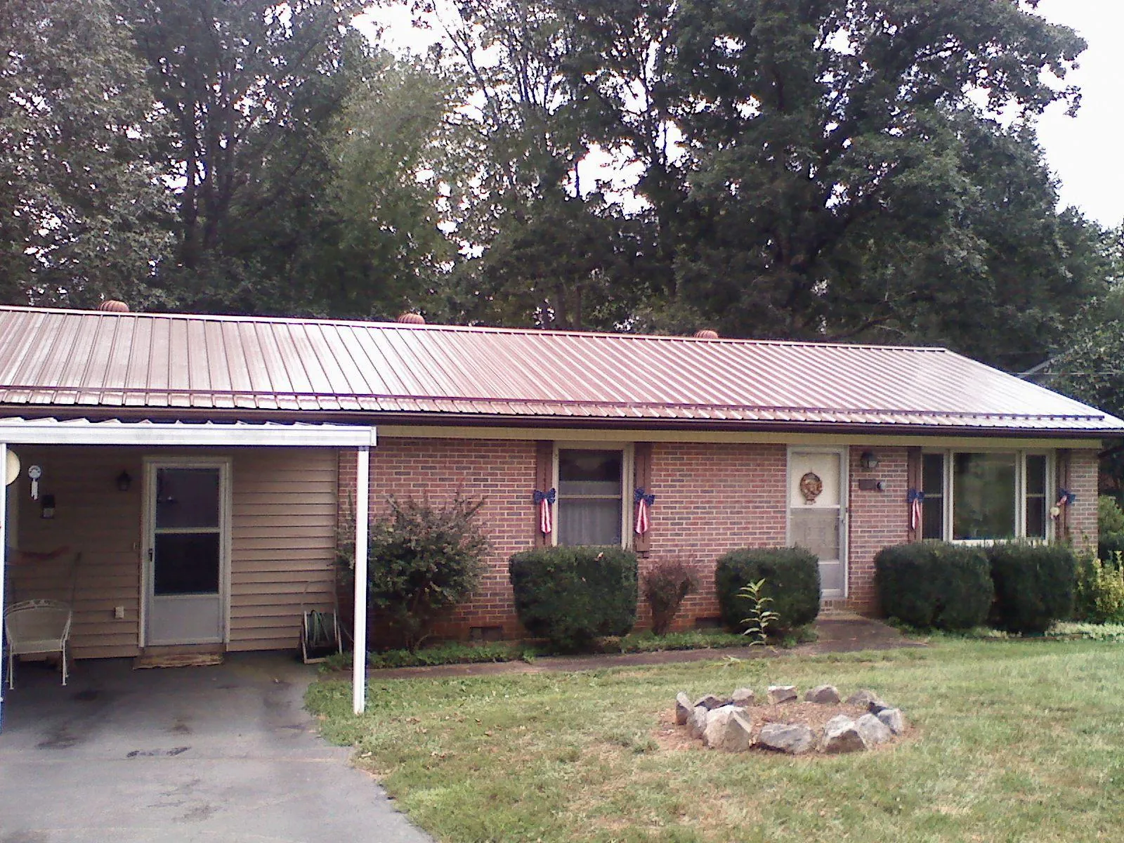 Bronze metal roof and carport on a brick ranch home — Roof Repair work by our crew in Beckley
