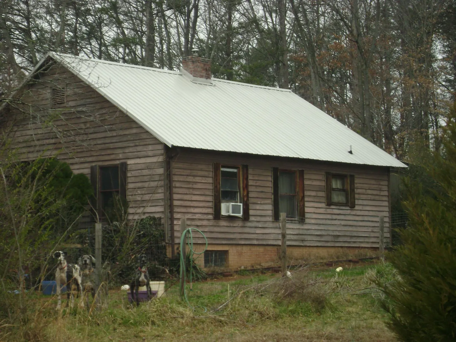 White metal roof on an old wood sided farmhouse, from a Metal Roof Installation job in Beckley